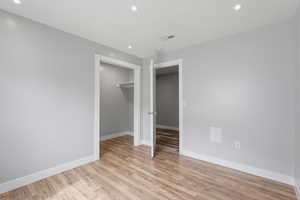 Unfurnished bedroom featuring light wood-type flooring, a closet, and recessed lighting