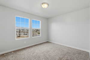 Carpeted empty room featuring baseboards
