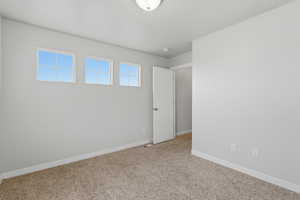 Carpeted empty room with baseboards
