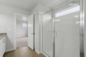 Full bathroom featuring vanity, a stall shower, and light tile patterned flooring