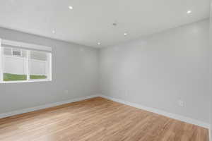 Spare room with light wood-style floors and recessed lighting