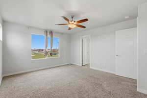 Unfurnished bedroom featuring light carpet and a ceiling fan