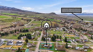 Aerial view of residential area featuring property boundaries highlighted and a mountainous background