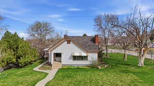 Bungalow-style home featuring a front lawn and a chimney