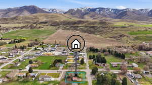 Aerial view of property and surrounding area featuring property parcel outlined and a mountain backdrop