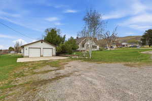 View of front of house with a front lawn, a garage, an outdoor structure, and a mountain view