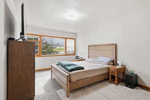 Bedroom with light carpet and a textured ceiling