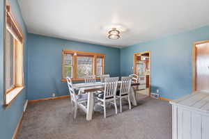 Dining area with light colored carpet and baseboards