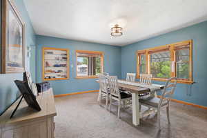 Carpeted dining area featuring baseboards