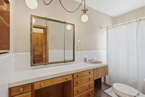 Full bath with vanity and a textured ceiling