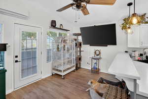 Living area with ceiling fan, light wood-style flooring, and lofted ceiling
