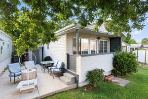 Rear view of property with a patio, a lawn, and a storage unit