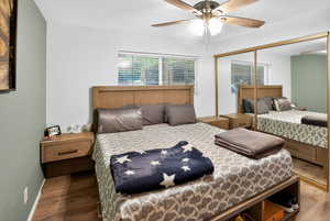 Bedroom with a closet, a ceiling fan, and dark wood finished floors