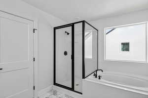 Full bath featuring a shower stall, light marble finish floors, and a bath
