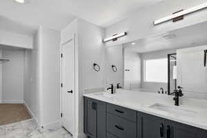 Bathroom with a textured ceiling, double vanity, light marble finish flooring, a stall shower, and a garden tub