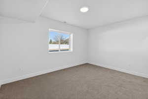 Carpeted empty room with baseboards