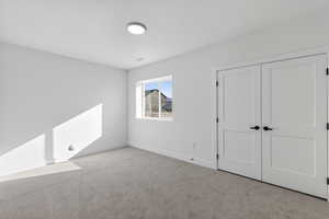 Unfurnished bedroom with carpet and a closet