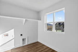 Laundry area featuring dark wood-type flooring, hookup for a washing machine, and electric dryer hookup