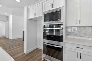 Kitchen featuring stainless steel appliances, white cabinetry, dark wood-type flooring, recessed lighting, and a textured ceiling
