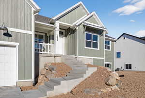 View of front of home featuring roof with shingles, a garage, and board and batten siding