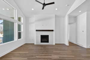 Unfurnished living room featuring a ceiling fan, recessed lighting, dark wood-type flooring, and a tile fireplace