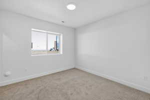 Unfurnished room featuring baseboards and light colored carpet