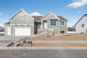 View of front of property with driveway and roof with shingles
