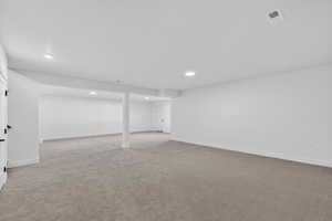 Finished basement featuring light carpet and recessed lighting