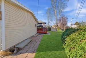 View of green lawn featuring a storage shed
