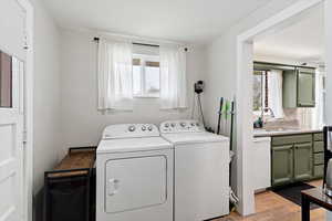 Laundry area with light wood-style floors and washing machine and clothes dryer