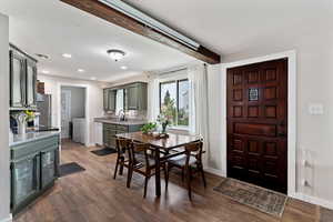 Dining area with dark wood-style floors, recessed lighting, and beam ceiling