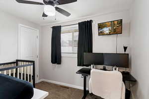 Bedroom featuring carpet, a crib, and ceiling fan