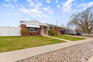 View of front of property featuring a carport, brick siding, and concrete driveway