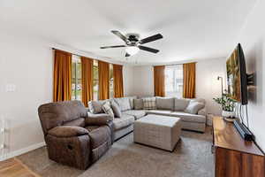 Living room featuring ceiling fan and baseboards