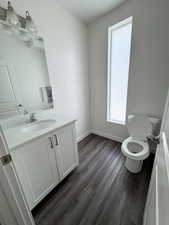 Half bathroom with vanity, dark wood finished floors, and a textured ceiling