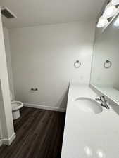 primary bath with vanity, dark wood-style flooring, and a textured ceiling