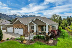 Craftsman inspired home featuring stone siding, an attached garage, driveway, roof with shingles, and a porch