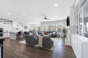 Living room featuring dark wood-style floors, ceiling fan, and recessed lighting
