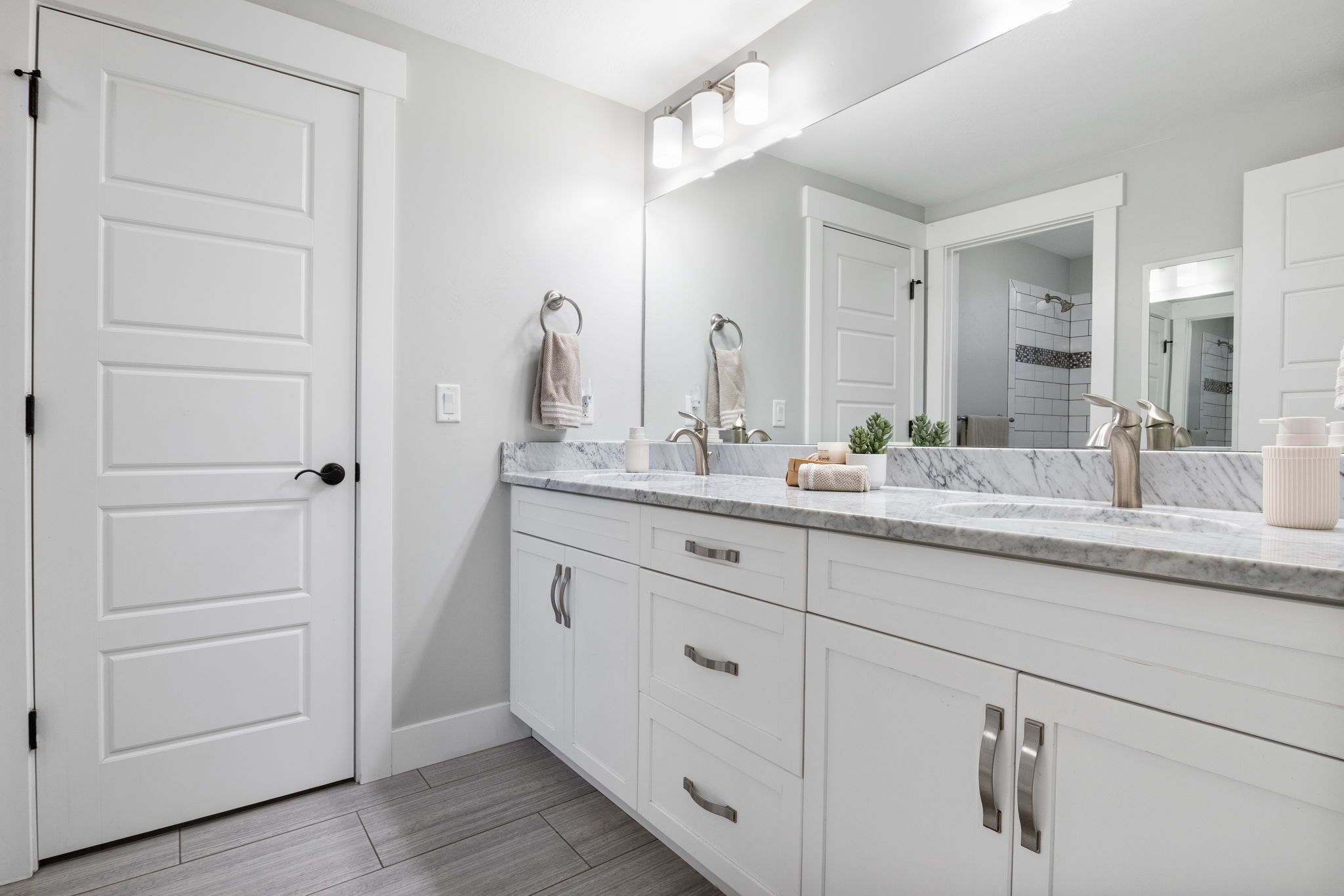 Full bath featuring double vanity and a tile shower