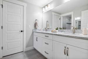 Full bath featuring double vanity and a tile shower