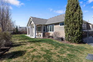Rear view of house with a fenced backyard, a patio area, and roof with shingles