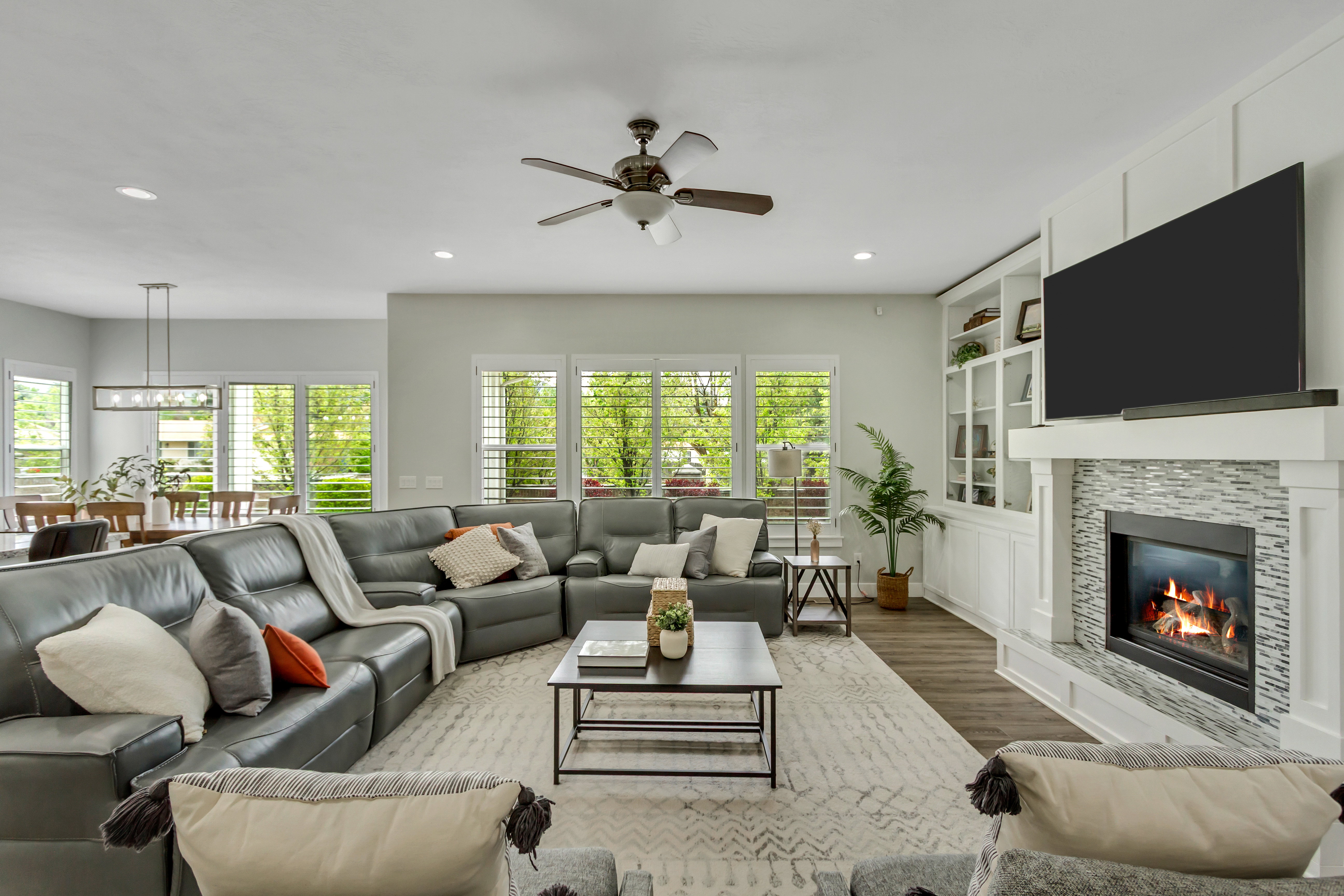 Living area with wood finished floors, a fireplace, a ceiling fan, recessed lighting, and built in shelves