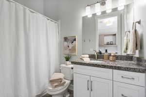 Full bath featuring a shower with shower curtain and vanity