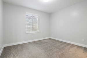 Unfurnished room with light colored carpet and baseboards