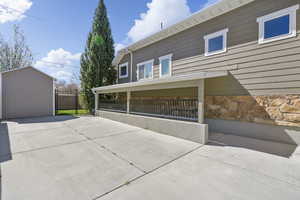 View of home's exterior featuring stone siding and an outdoor structure