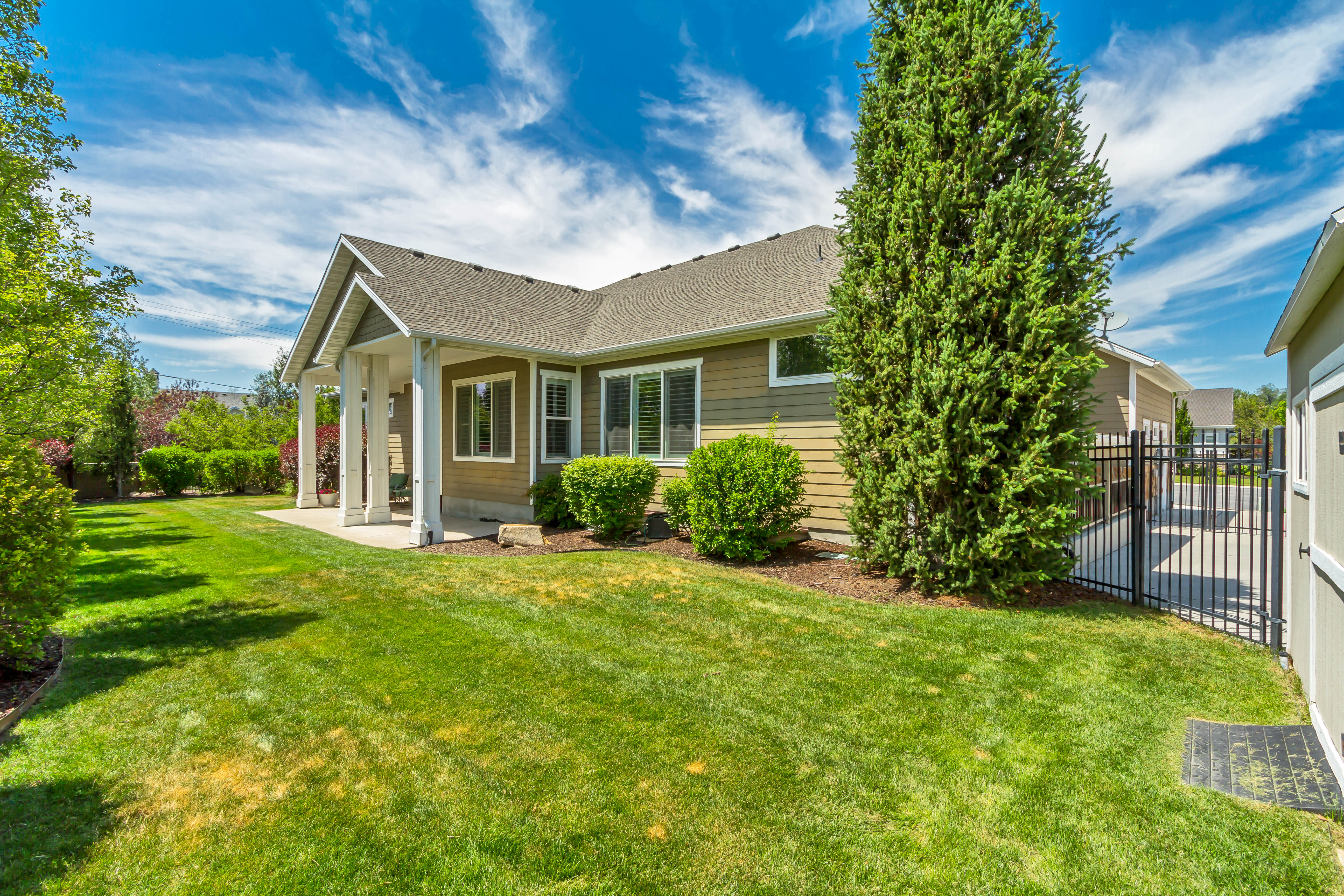 Expansive green lawn with established landscaping, including mature trees and shrubs