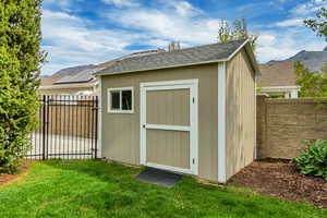 View of shed with a mountain view, a fenced backyard, and a gate