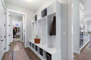 Mudroom with dark wood finished floors and baseboards