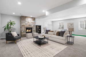 Living room featuring carpet, a fireplace, and recessed lighting