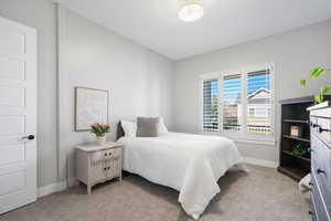 Bedroom featuring light carpet